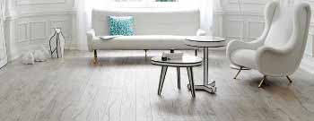 Ein Wohnzimmer mit weißen Möbeln und Holzböden. Firmenadresse