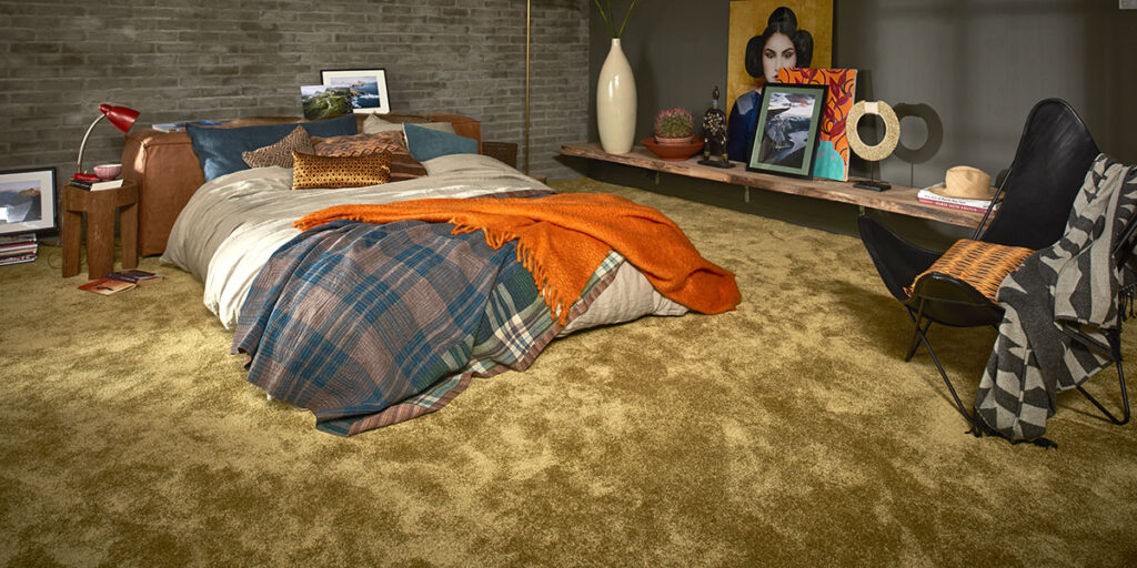Ein Schlafzimmer mit einem Bett, einem Nachttisch und Teppichboden. Firmenadresse