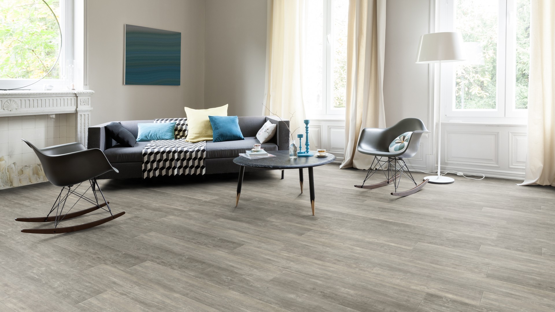 Ein Wohnzimmer mit Holzböden und grauen Möbeln. Firmenadresse