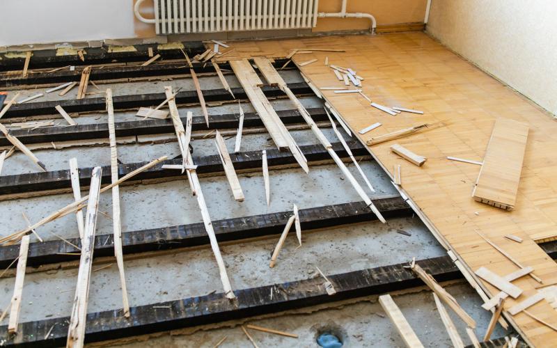 Altbelag fachgerecht Entsorgen - Ein Raum mit Holzboden und Holzbrettern. Firmenadresse