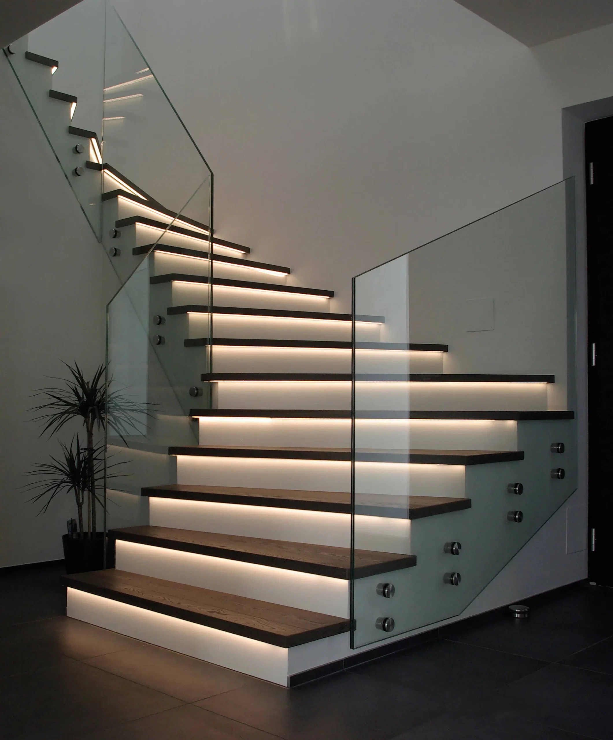 Eine moderne Treppe mit Glasgeländer und LED Beleuchtung an den Treppen - Stufen. Firmenadresse