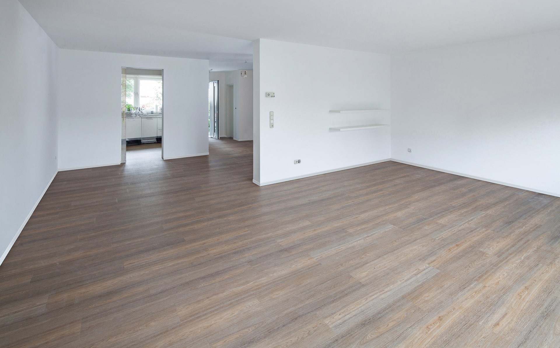Ein leerer Raum mit Holzböden und weißen Wänden. Firmenadresse