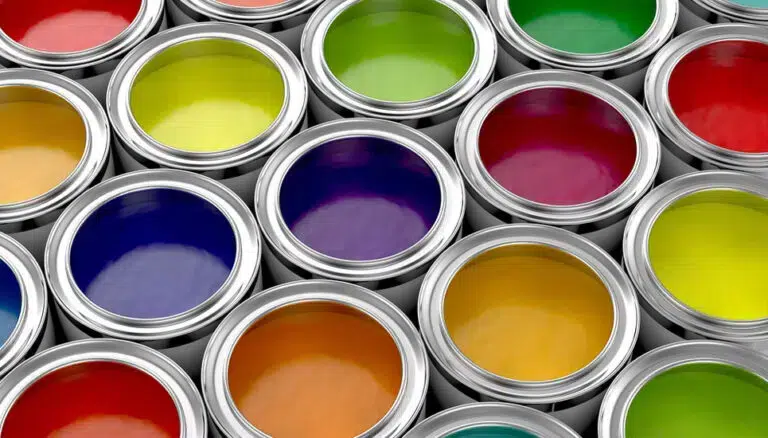 Offene Farbdosen, die in einem Raster angeordnet sind und verschiedene Farben enthalten, darunter Grün, Gelb, Lila, Blau, Rot und Orange. - Firmenadresse